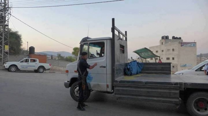 أحد أفراد الشـرطة الفلسطيـنية يقـدم الميـااه للسيـاارات المتـاخرة عـن الفطـورر اثنـاء اذان المغـرب